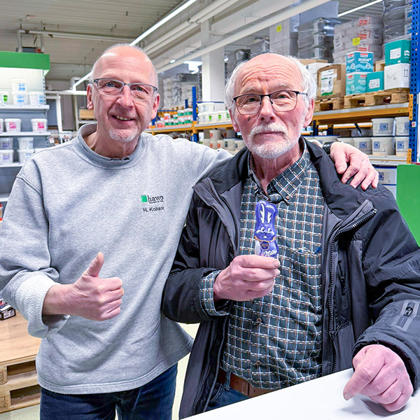 gl&uuml;cklicher Kunde mit seinem Milka Schmunzelhasen in Ludwigshafen und dem Filialleiter Hartmut Koback