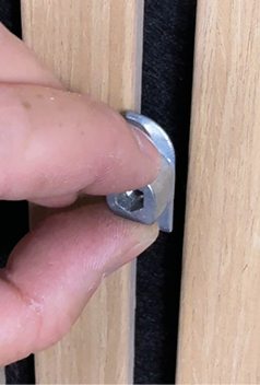 Einsetzen der Fluegelbefestigung zwischen den Latten der Akustikpaneele