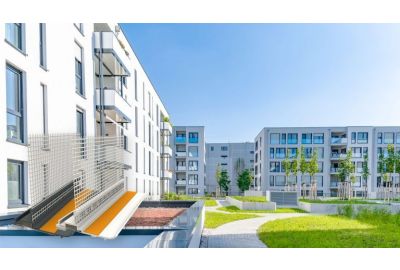 Moderne Wohnblöcke und ein kleiner Park bei Sonnenschein - Abbildung der Anputzleiste 3D Safe in weiß und anthrazit