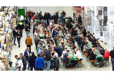 Seminarteilnehmer beim Mittagessen, sitzend auf Festbänke in Filiale Heilbronn