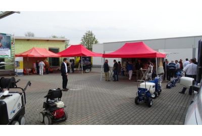 Ausstellungszelte in hawo-Hof mit Maschinen, Geräten und Leitern und zahlreichen Besuchern