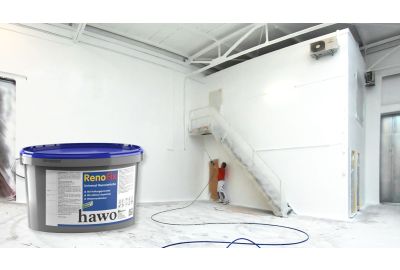 Maler mit Helm und Einwegmaske streich mit Hilfe vom JetRoller eine Wand blau