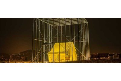 Das bedrohte Haus von Andreas Sarow - Haus beleuchtet im Käfig