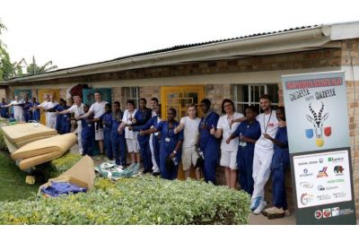 Gruppe von Malerinnen und Maler vor dem Haus in Ruanda