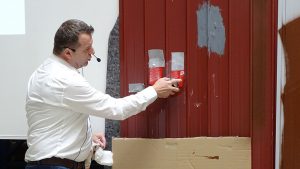 Referent von Rustoleum besprüht eine lackierte Fläche mit Abbeizspray