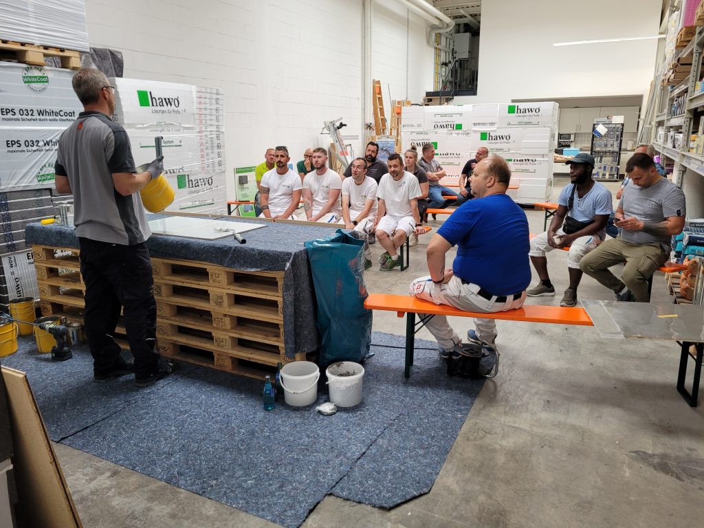 Anwendungstechniker erklärt und die Teilnehmer schauen ihm sitzend zu