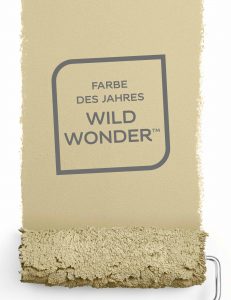 Farbstreifen ocker gestrichen mit der Walze - darauf steht in einem Quadrat mit zwei abgerundeten Ecken Farbe des Jahres Wild Wonder