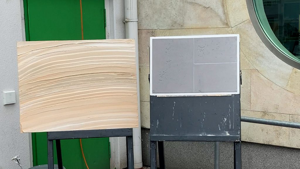 zei Musterplatten auf Staffeleien - Eine Saharaoptik - die andere Betonoptik