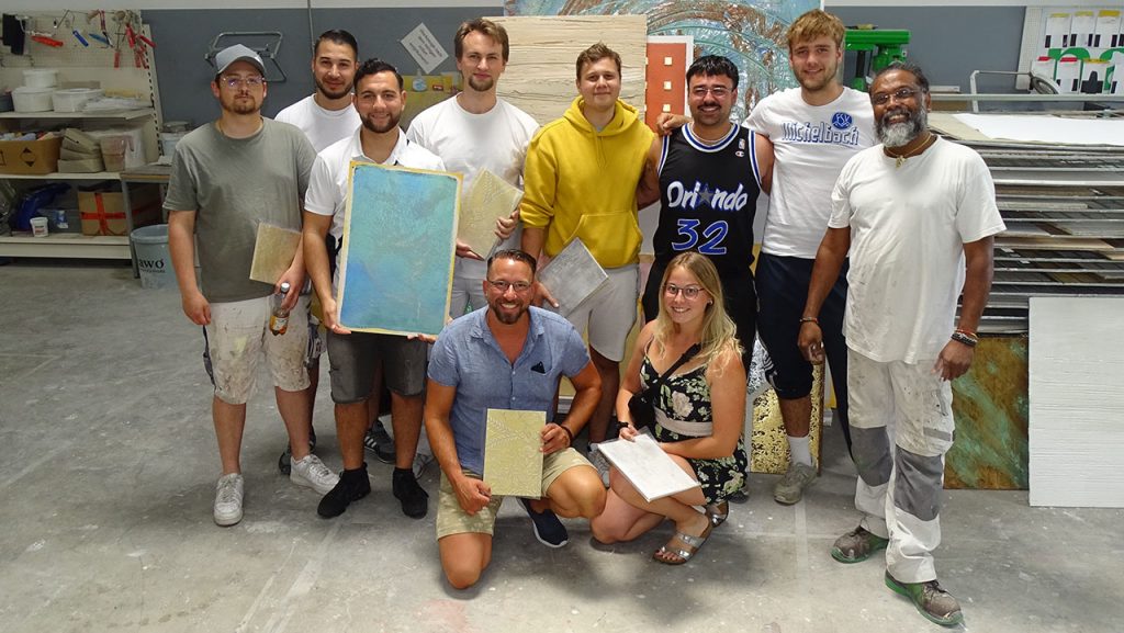 Gruppenbild mit lachenden Teilnehmern und ihren Musterplatten
