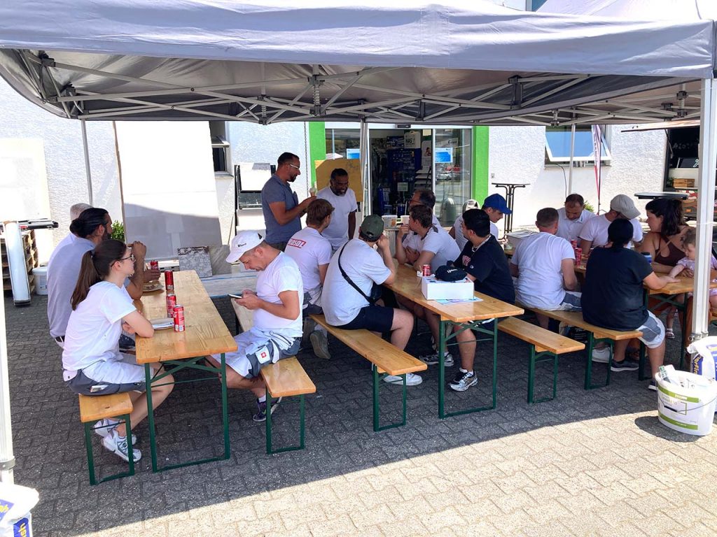 Viele Menschen auf den Bierzeltgarnituren im Schatten
