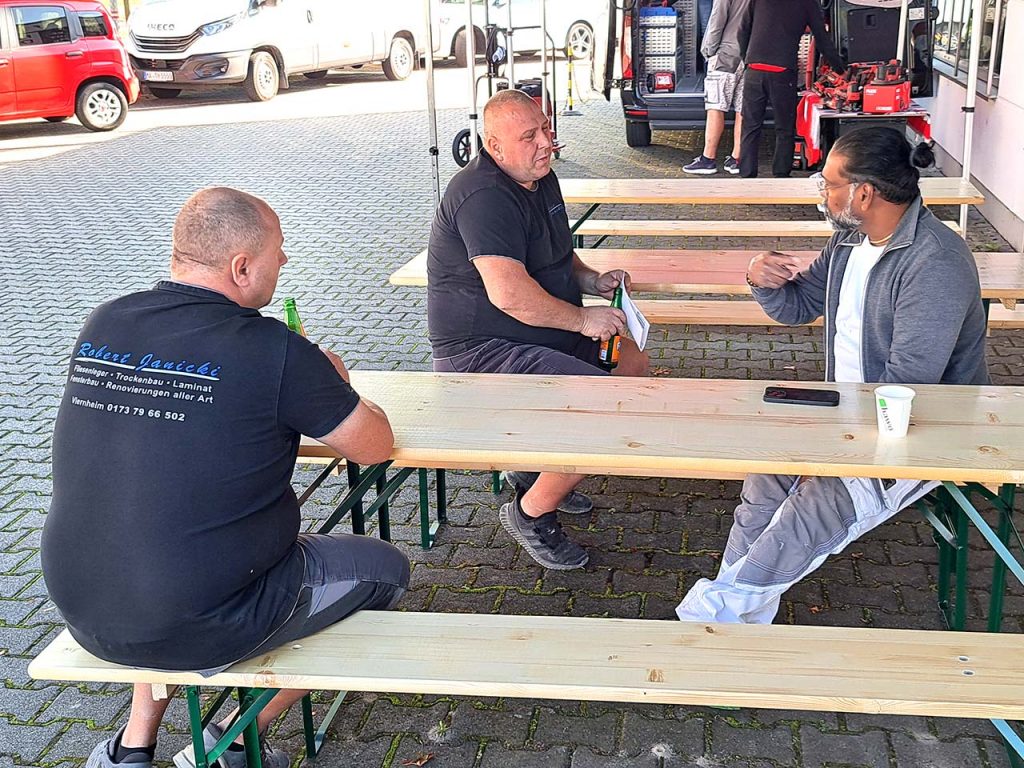 Dilip unterhält sich angeregt mit Kunden im Essensbereich