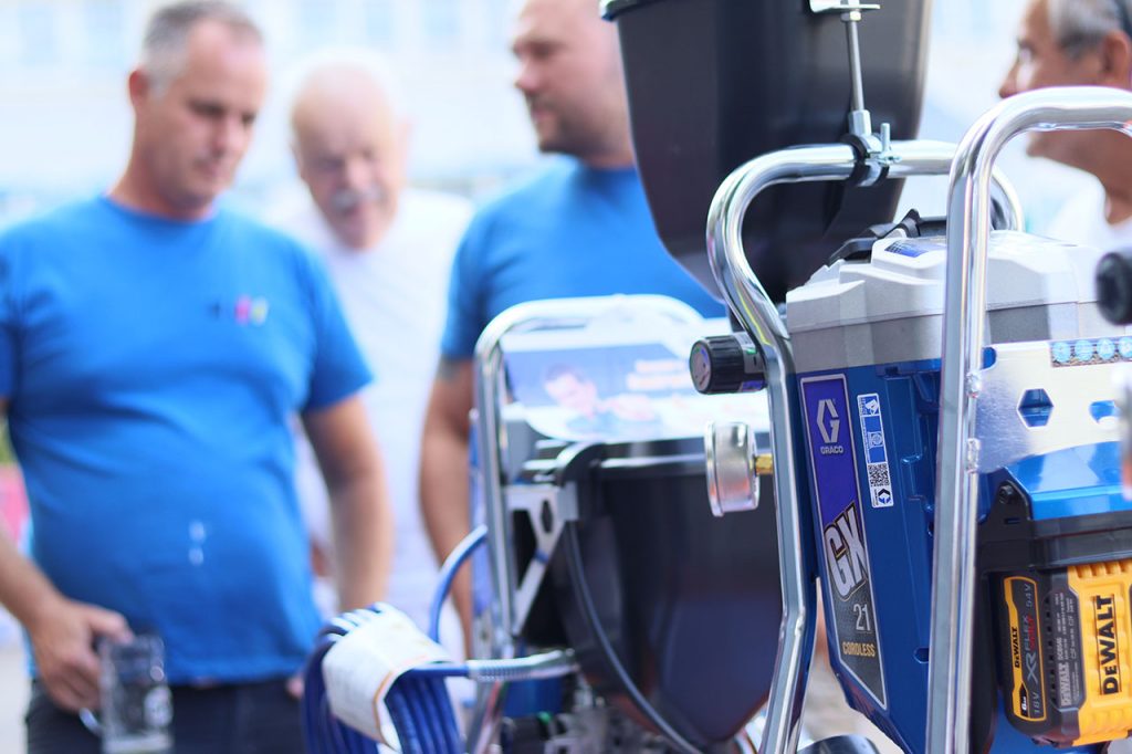 Detailaufnahme mit Tiefenschärfe - Graco GX 21 Akku mit Kunden im Hintergrund
