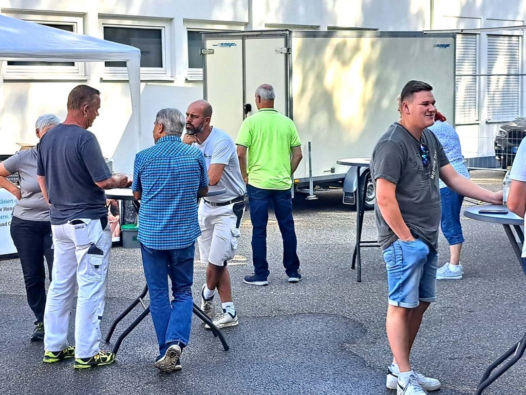 Kunden an Stehtischen im Aussenbereich