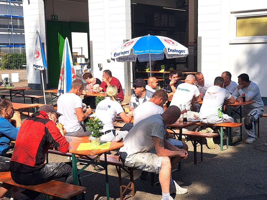 Kunden im Sonnenschein beim Essen und Trinken