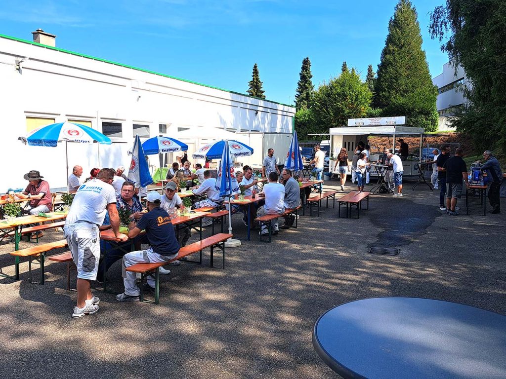 vielzahl an Personen im Aussenbereich mit Sonnenschein