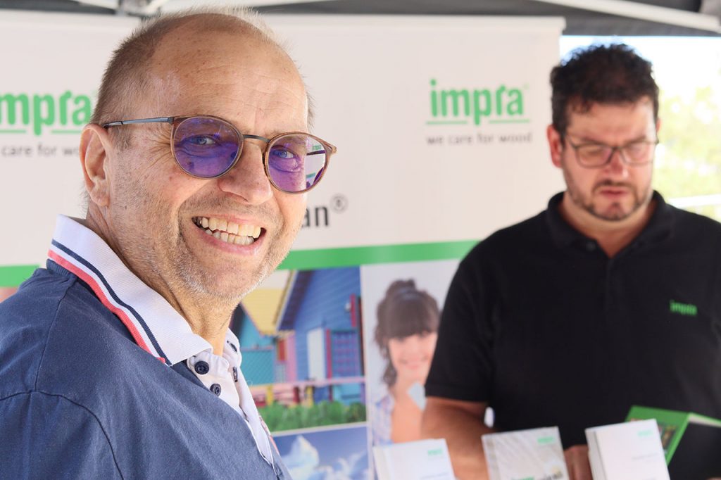 Der impra-Stand mit einem lachenden Mann