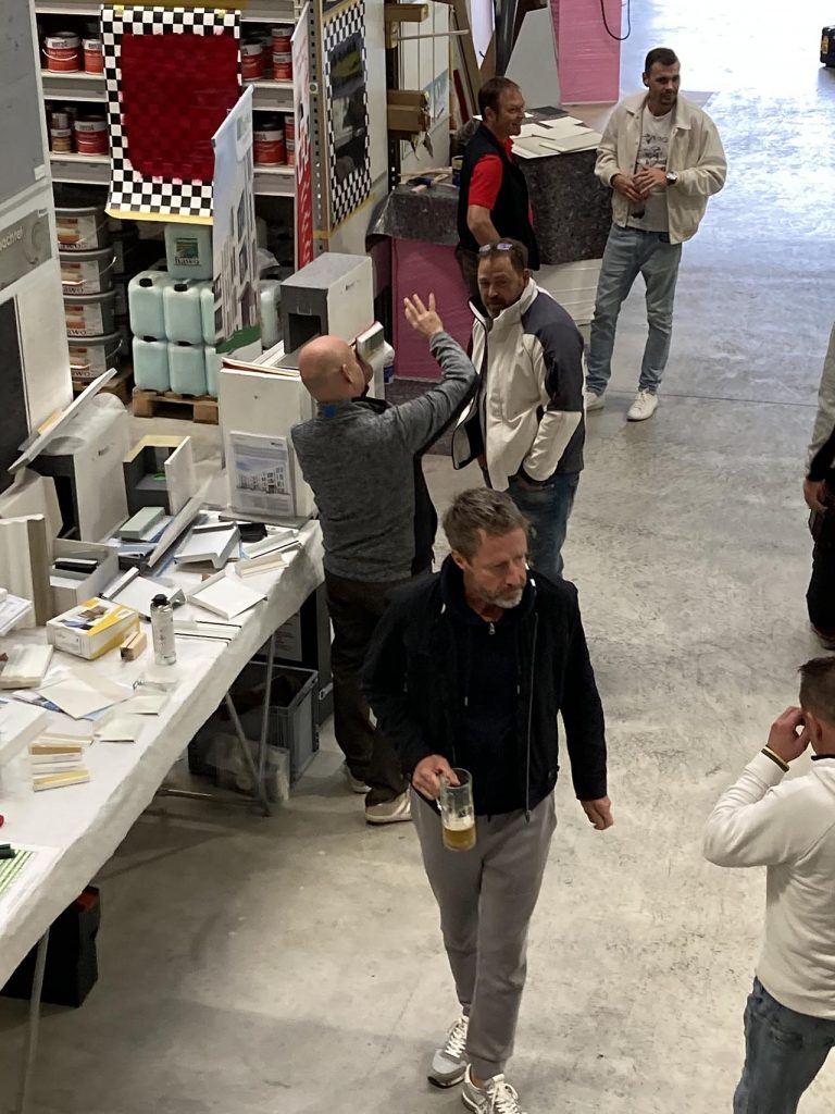 Foto von der ersten Etage in den Verkaufsraum - Kunden informieren sich an den Ständen