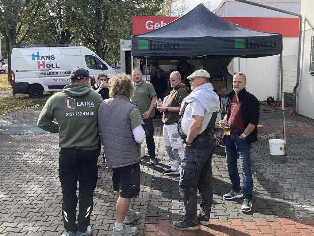 Kunden unterhalten sich vor der hawo Filiale in Karlsruhe