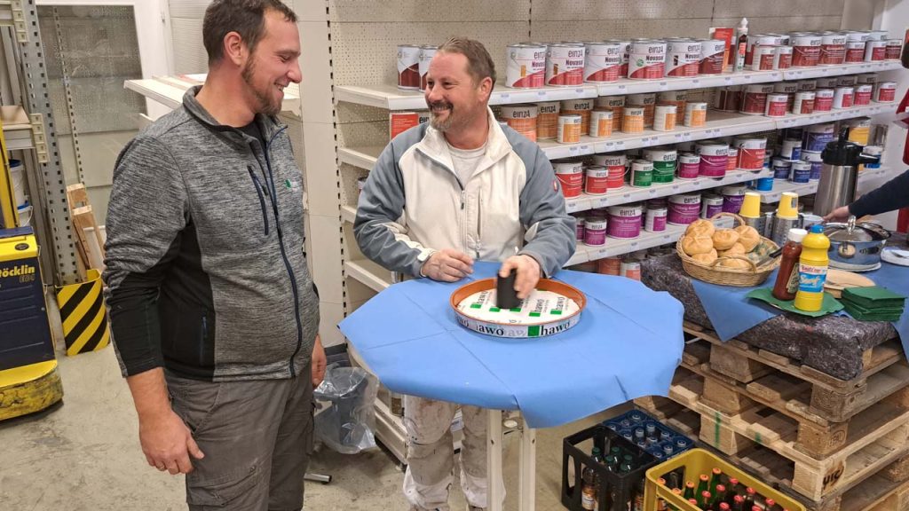 Christian Horn mit seinem Kunden beim Rabatt würfeln