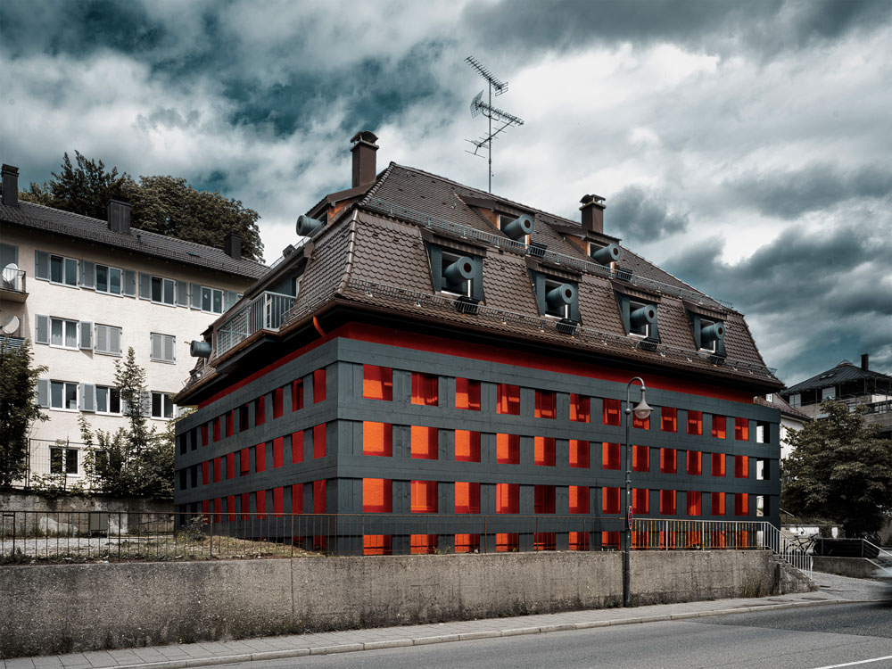 Mehrfamilienhaus mit knalligem Rot und Schwarz gestrichen