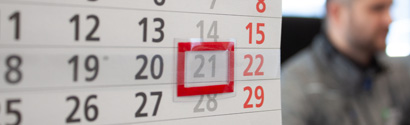 Kalender mit unscharfer Person im Hintergrund