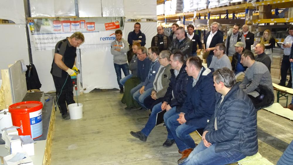 Matthias Neff beim Aufrühren von Remmers MB 2K Multi-Baudicht mit Rührgerät - Teilnehmer schauen zu