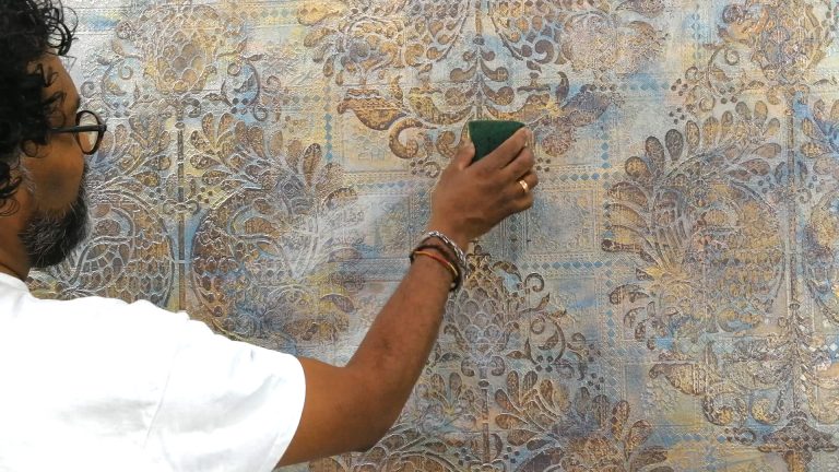 Dilip trägt Naturwachs vollflächig mit einem Schwamm auf.