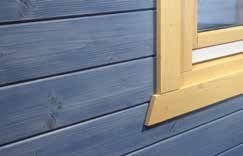 Blaue Holzfassade mit beiger Fensterumrandung