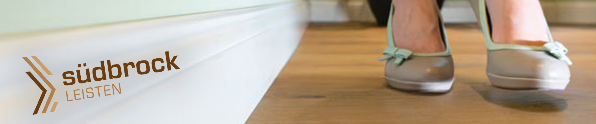 Holtfussboden mit wei&szlig;er Holzrandleiste - Leisten-Kollektion, Brosch&uuml;re und S&uuml;dbrock-Logo im Vordergrund