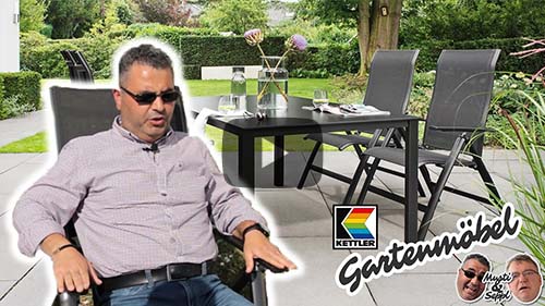 Titelbild des YouTube-Videos Musti uns Seppl - Folge 2 - Energie sparen - Musti sitzt im Gartenstuhl, dahinter eine Kettler Gartensitzgruppe