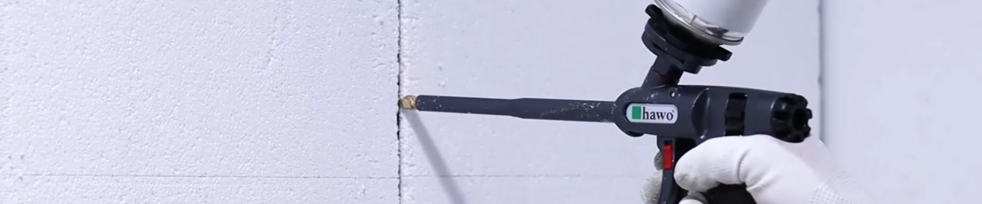 Schaumpistole mit Messingspitze und Füllschaum füllt eine Ritze zwischen zwei Dämmplatten
